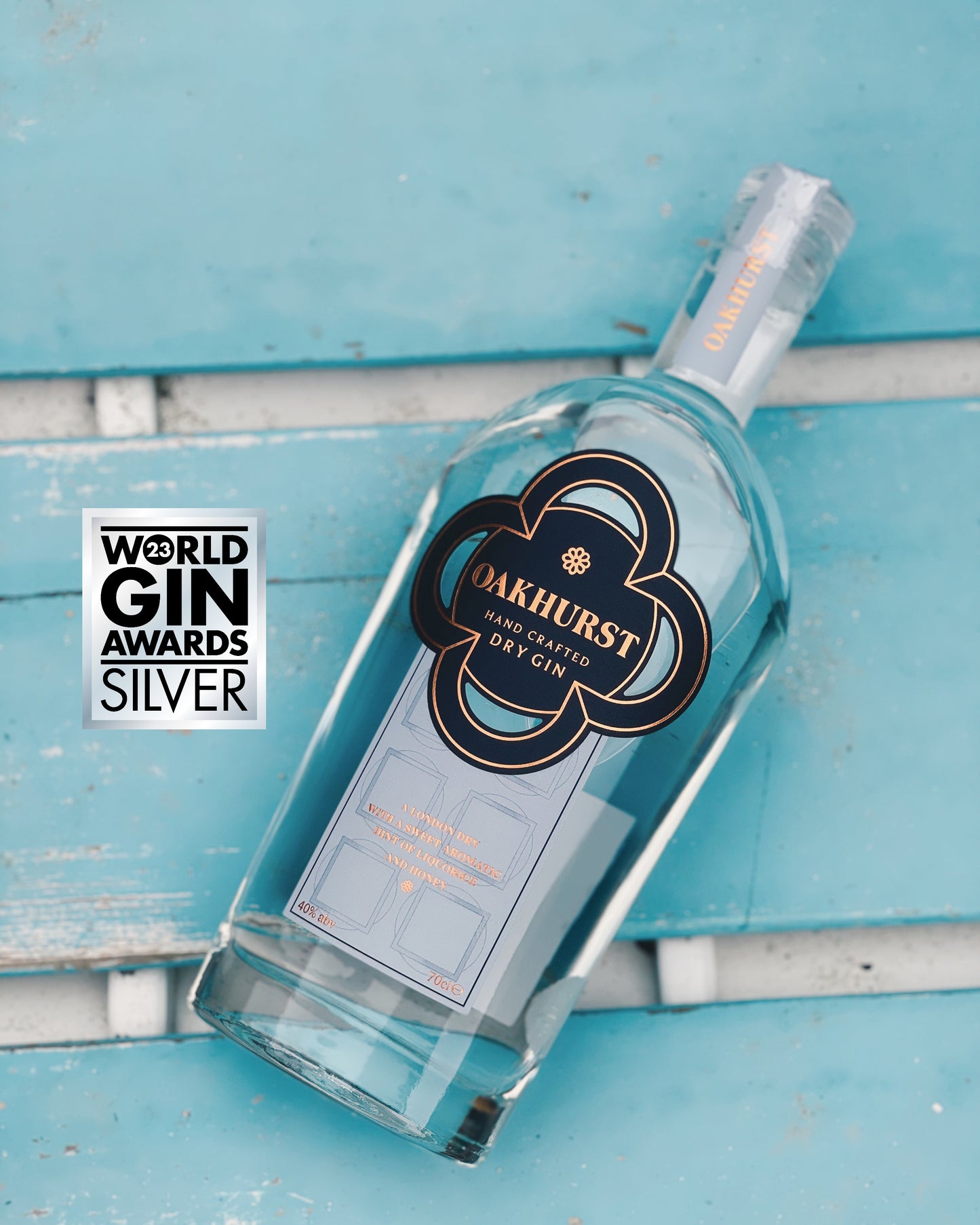 A bottle of luxury Award Winning Oakhurst Gin on a blue background.